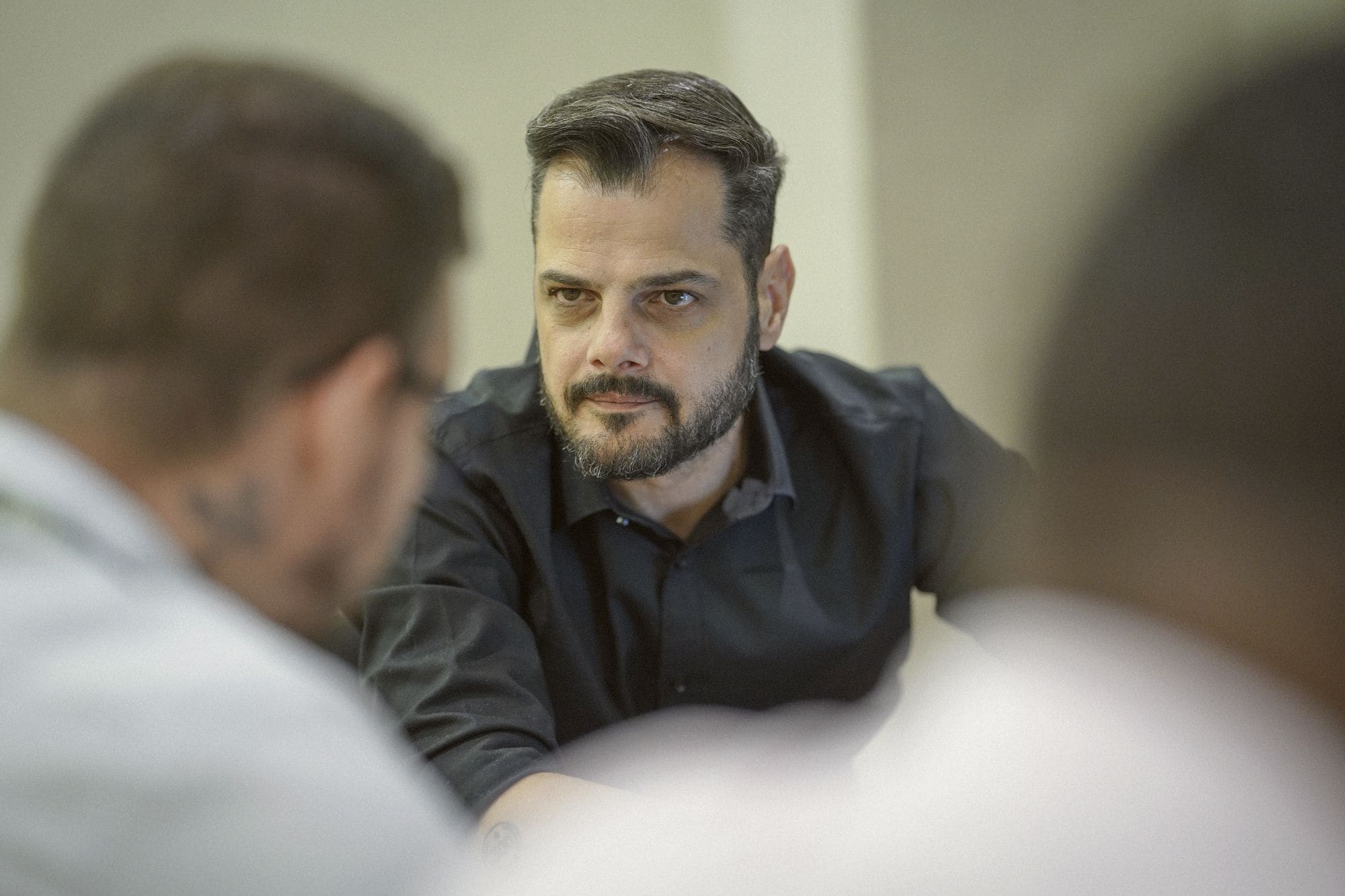 Giuseppe em reunião, olhando para o interlocutor